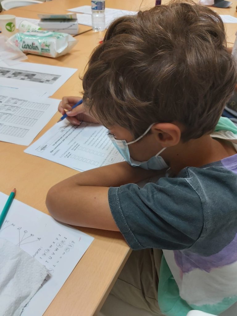 Un enfant travaille sur une activité écrite